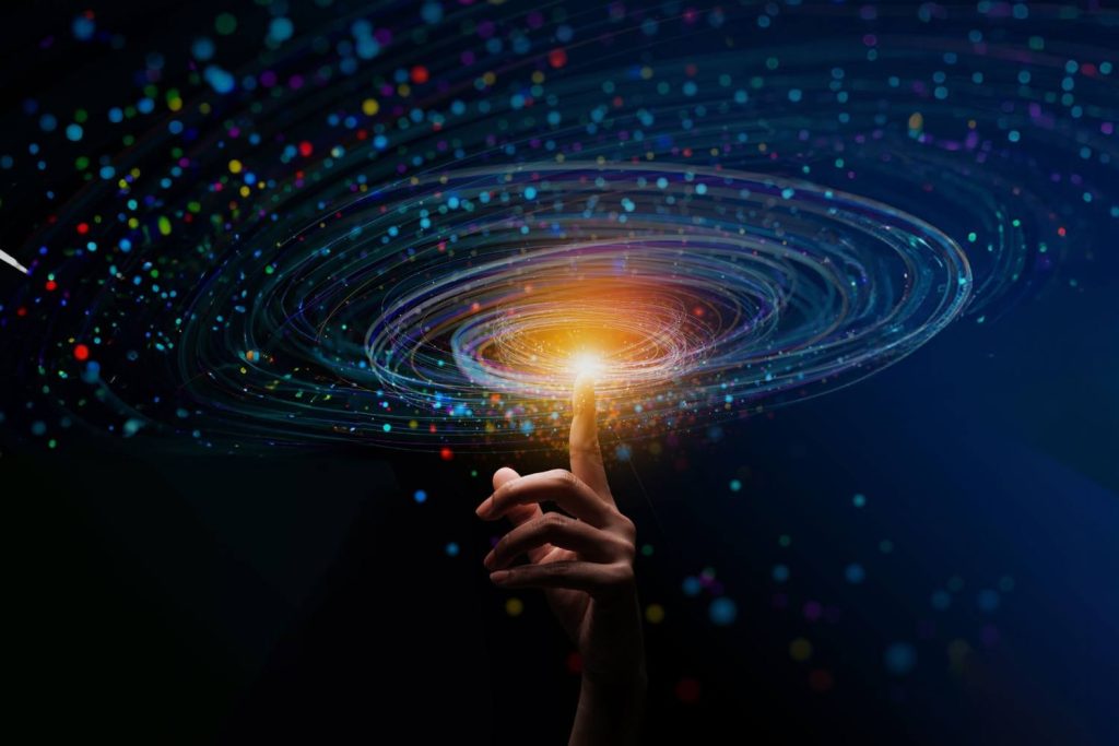 Mano tocando una esfera luminosa con efecto de red de datos, representando la conectividad avanzada de GigaREACH XL de CommScope.